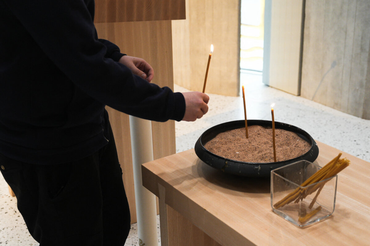 A teenager lights a candle during a church service at the Lutheran Tikkurila Church in Vantaa, Finland, on April 3, 2024. (Alessandro Rampazzo/AFP via Getty Images)
