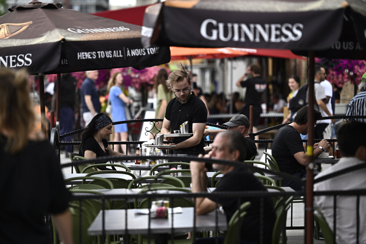 A server works on the patio of a pub in the ByWard Market in Ottawa, on June 23, 2023. (The Canadian Press/Justin Tang)
