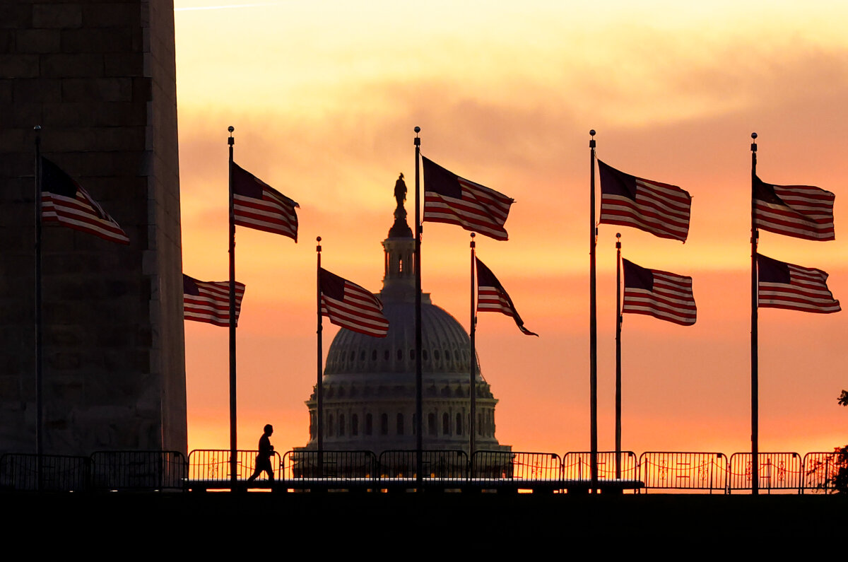 A runner passes the Washington Monument with the dome of the U.S. Capitol in the background at sunrise in Washington on Oct. 1, 2025. The U.S. federal government shut down much of it's operations overnight after Congress failed to pass a bipartisan funding bill. (Kevin Dietsch/Getty Images)