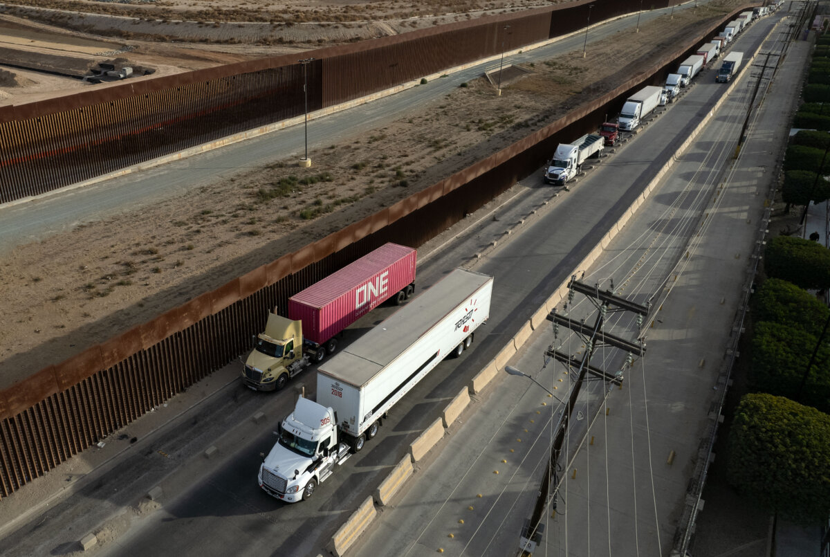 Trucks line up next to the border wall before crossing to the United States at Otay commercial port in Tijuana, Mexico, on Jan. 22, 2025. (Guillermo Arias/AFP via Getty Images)