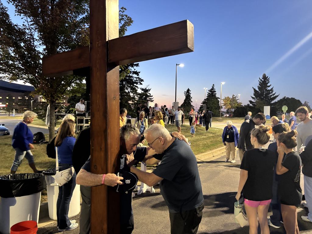 Dan Beazley prays with Ed Chandler, a Michigan pastor, at a Sept. 30 vigil in Grand Blanc, Mich., for victims of the shooting at a chapel of the Church of Jesus Christ of Latter-day Saints in Grand Blanc. (Jeff Louderback/The Epoch Times)