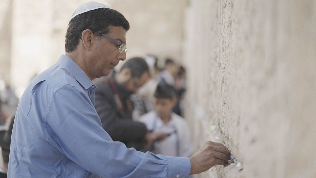 Dinesh D'Souza placing a prayer in Jerusalem's Western Wall in the documentary, "The Dragon's Prophecy." (The Dragon's Prophecy)