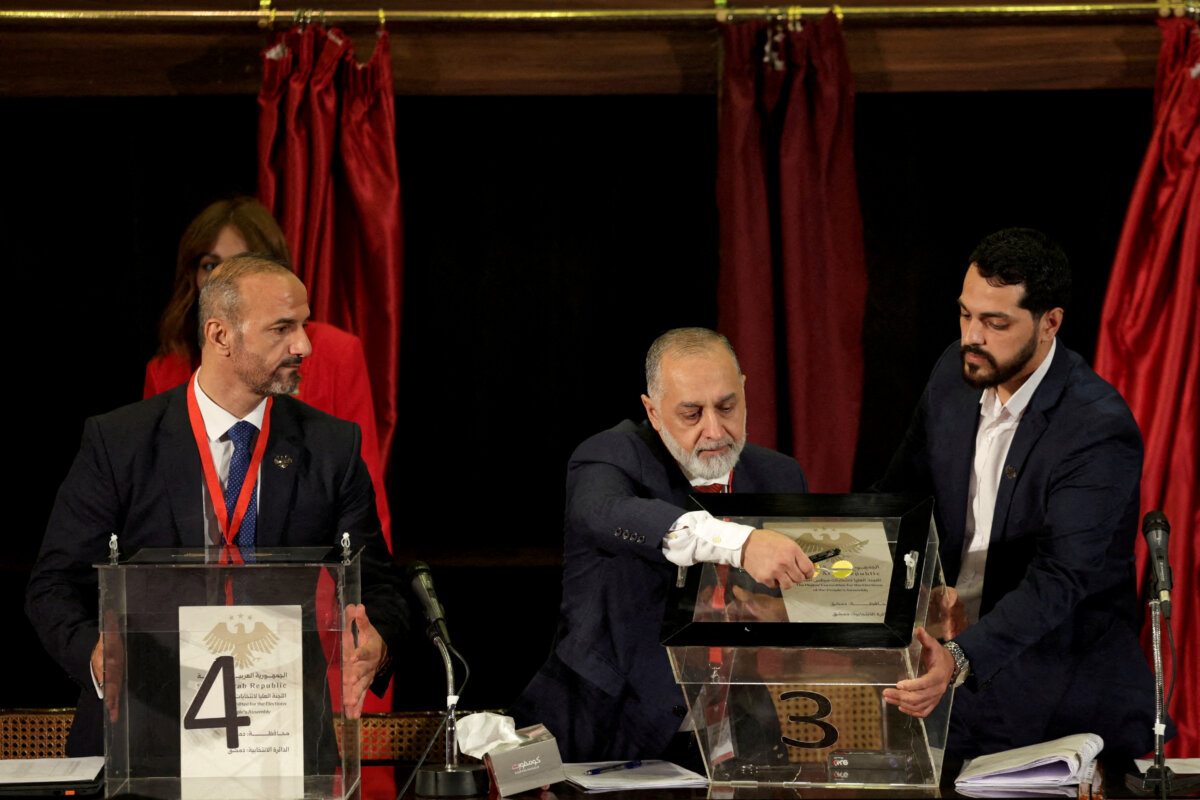 An electoral college member opens a ballot box during a vote to select incoming members of Syria's parliament, in Syria on Oct. 5, 2025. (Khalil Ashawi/Reuters)