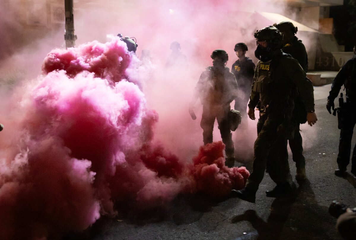 Federal officers deploy smoke grenades to deter protesters in front of Immigration and Customs Enforcement offices in Portland, Ore., on Oct. 5, 2025. (John Fredricks/The Epoch Times)