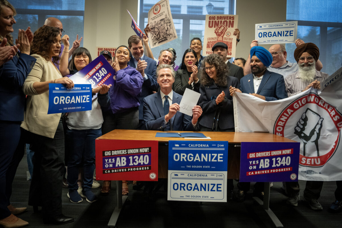 California Gov. Gavin Newsom signs a new law on Oct. 3, allowing rideshare drivers to unionize starting Jan. 1, 2026. (California Governor's Office)