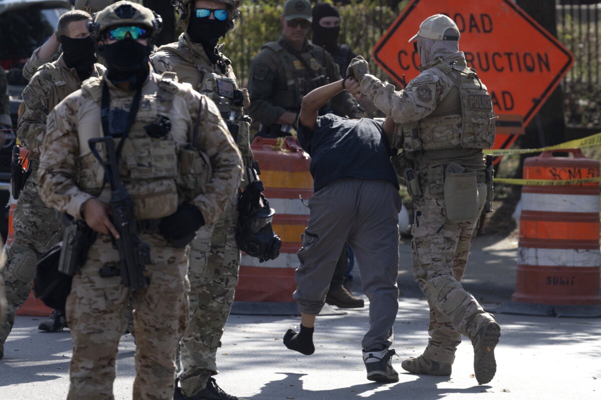 Police take a man into custody as community members and activists confront federal law enforcement agents for reportedly shooting a woman in the Brighton Park neighborhood in Broadview, Ill., on Oct. 4, 2025. (Scott Olson/Getty Images)