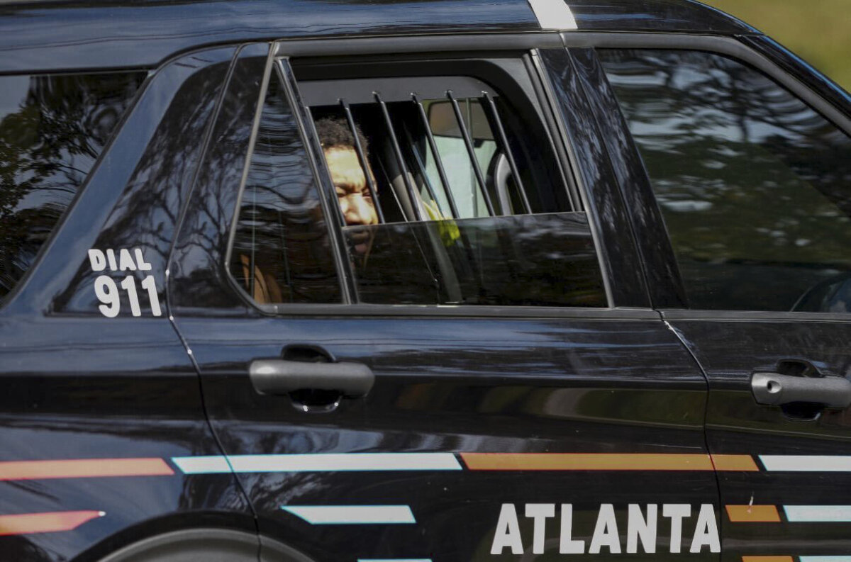 Derrick Groves, the last escapee from the New Orleans jailbreak in May, sits in a police vehicle after being taken into custody by U.S. Marshals and Atlanta police at a southwest Atlanta home, on Oct. 8, 2025. (Ben Hendren/Atlanta Journal-Constitution via AP)