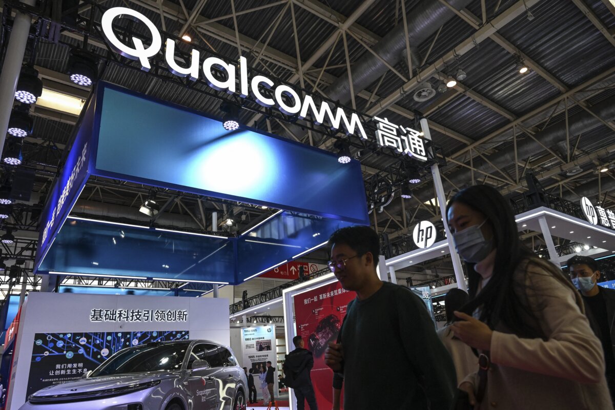 People walk past a Qualcomm booth during the China International Supply Chain Expo (CISCE) in Beijing on Dec. 1, 2023. (Jade Gao/AFP via Getty Images)