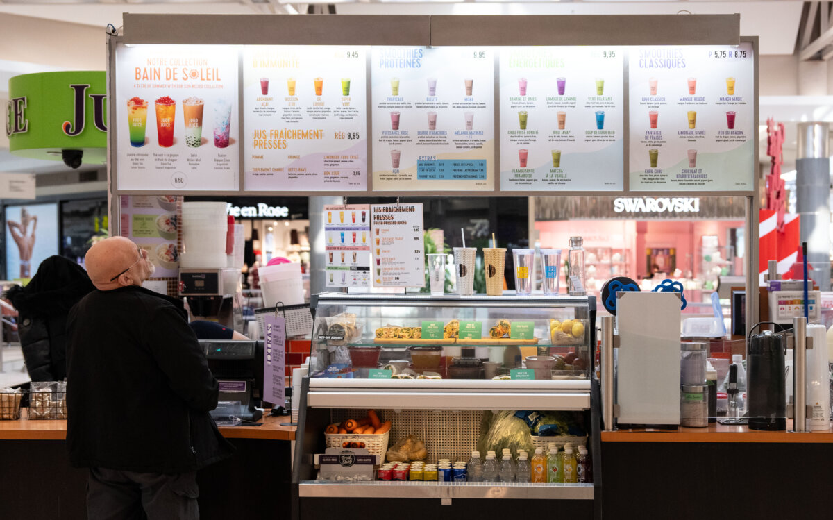 A man looks to order from Jugo Juice, part of MTY Food Group Inc., in a mall in Montreal on Dec. 2, 2024. (The Canadian Press/Christinne Muschi)