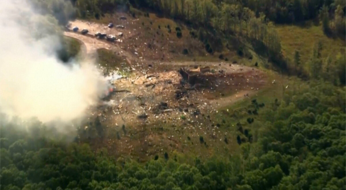 Smoke fills the air as debris covers the ground and vehicles after a powerful blast ripped through a military explosives manufacturing plant in Hickman County, Tenn., on Oct. 10, 2025. (WTVF-TV via AP)
