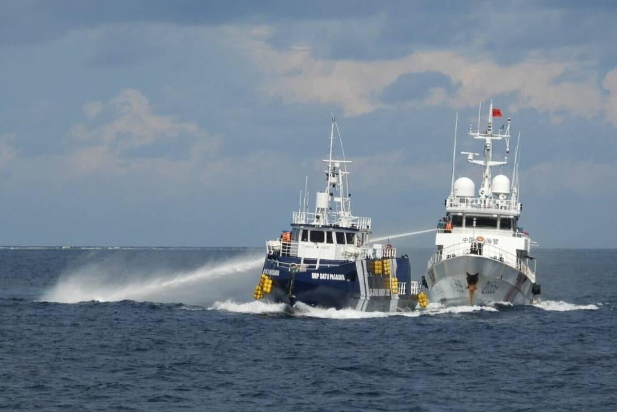 A Chinese Coast Guard vessel (R) fires its water cannon at the Philippine BRP Datu Pagbuaya near Philippine-occupied Thitu Island, locally called Pag-asa Island, at the West Philippine Sea on Oct. 12, 2025. (Philippine Coast Guard via AP)