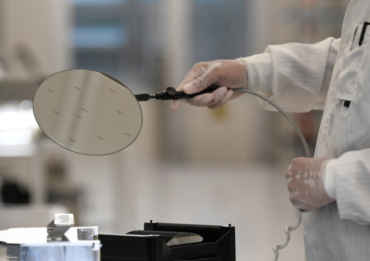 An employee works with a wafer in a production line of Dutch semiconductor company Nexperia, in Hamburg, Germany, on June 27, 2024. (Fabian Bimmer/Reuters)