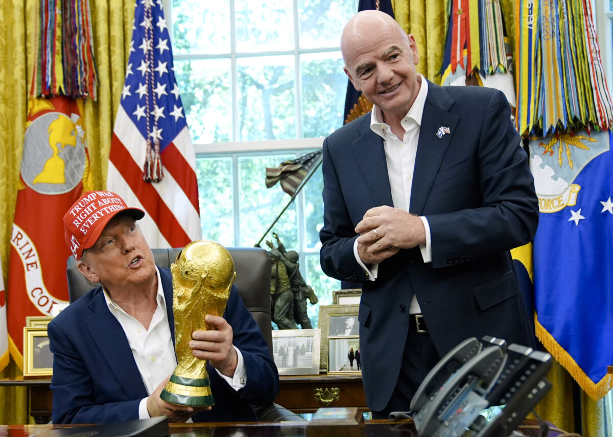 President Donald Trump holds the FIFA World Cup Winners Trophy as FIFA President Gianni Infantino looks on during an announcement in the Oval Office of the White House, Aug. 22, 2025. (Jacquelyn Martin/AP Photo)