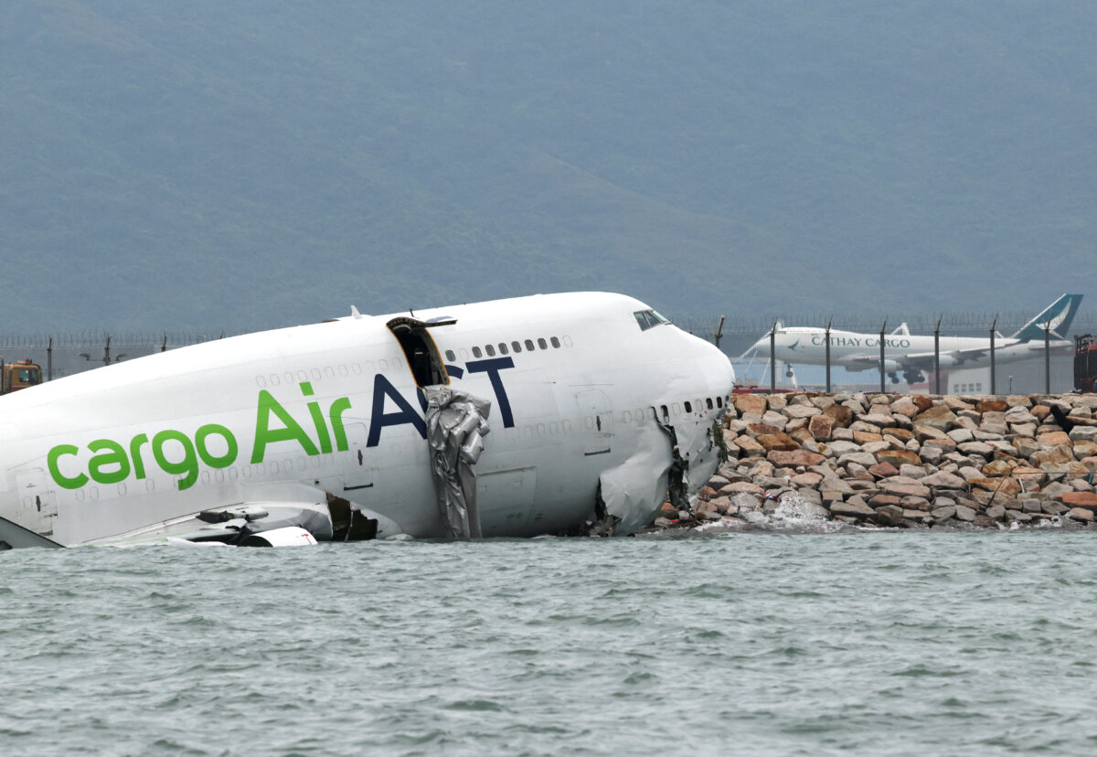 A cargo plane lies partially in the sea after veering off the runway during landing at Hong Kong International Airport in Hong Kong, on Oct. 20, 2025. (Tyrone Siu/Reuters)