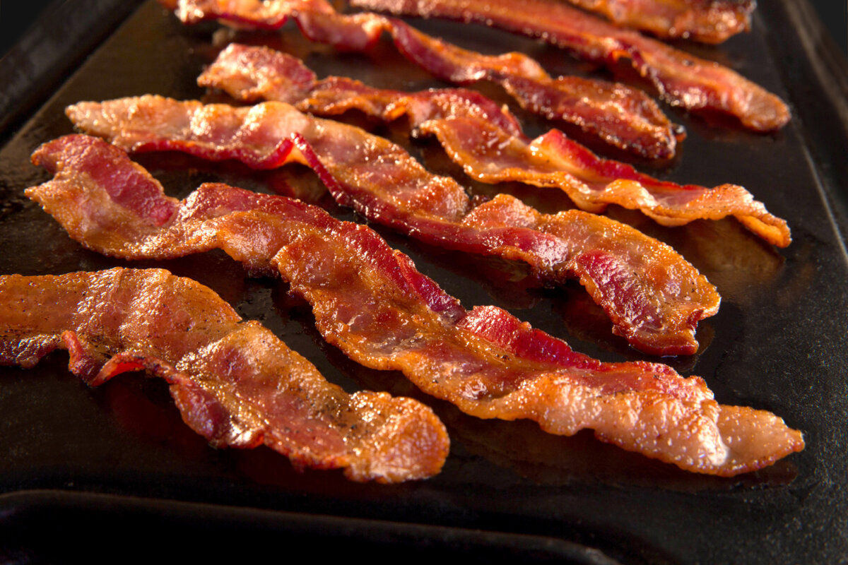 Strips of crispy bacon on a cast iron skillet. (Dreamstime/TNS)