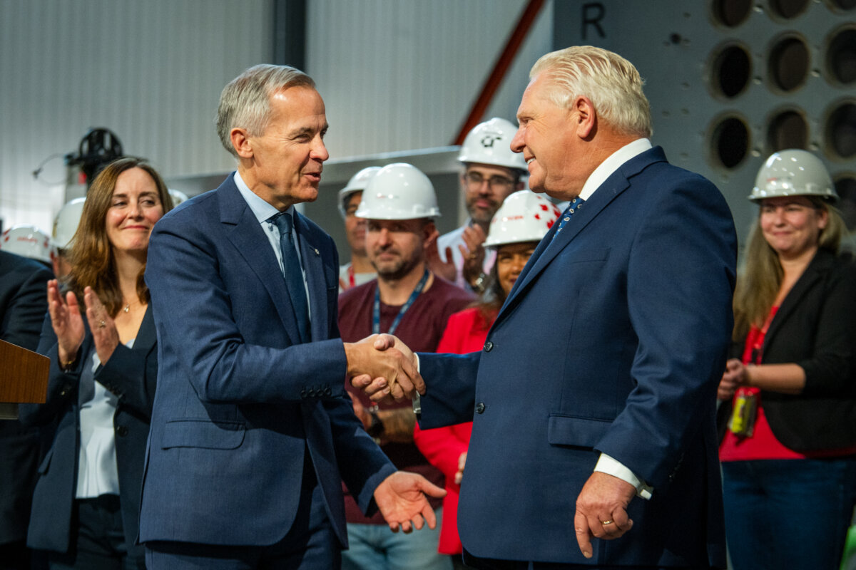 Prime Minister Mark Carney (L), shakes hands with Ontario Premier Doug Ford after the two made an announcement at the Darlington Energy Complex in Courtice, Ont., on Oct. 23, 2025. (The Canadian Press/Laura Proctor)