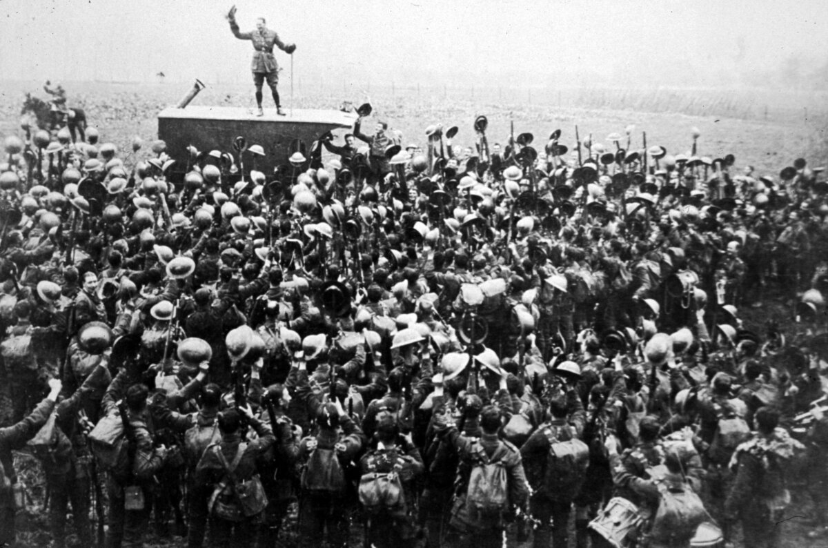 A crowd of soldiers on the Western Front cheer as an officer announces the news of the armistice between the Allies and Germany, in November 1918. (Archive Photos/Getty Images)