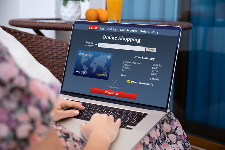 woman using online shopping application on computer laptop at home in room