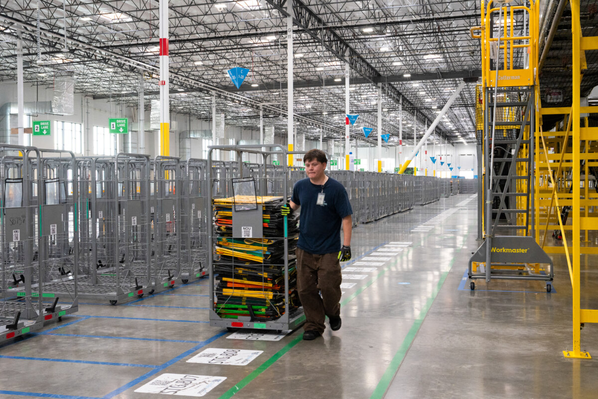 An employee carries sorting bags at Amazon's DUR3 Delivery Station in Milpitas, Calif., on Oct. 22, 2025. (Laure Andrillon/AFP via Getty Images)