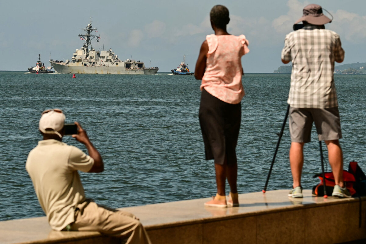 People watch and take pictures of the USS Gravely, a US Navy warship, departing the Port of Port of Spain on Oct. 30, 2025. The US warship arrived in Trinidad and Tobago on Oct. 26 for joint exercises near the coast of Venezuela, as Washington ratcheted up pressure on drug traffickers and Venezuelan leader Nicolás Maduro. (Martin Bernetti/AFP via Getty Images)
