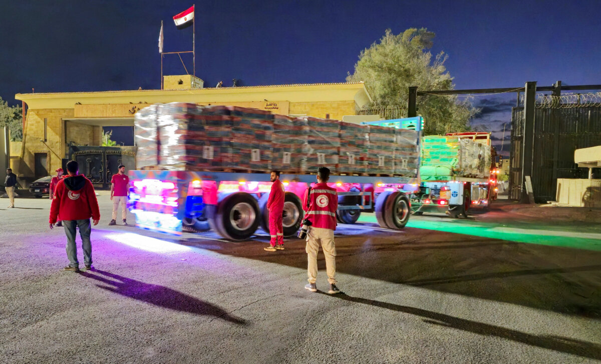 Trucks carrying aid bound for the Gaza Strip cross the border crossing between Egypt and the Gaza Strip, after a cease-fire between Israel and the Hamas terrorist group went into effect, in Rafah, Egypt, on Oct. 12, 2025. (STR/Reuters)
