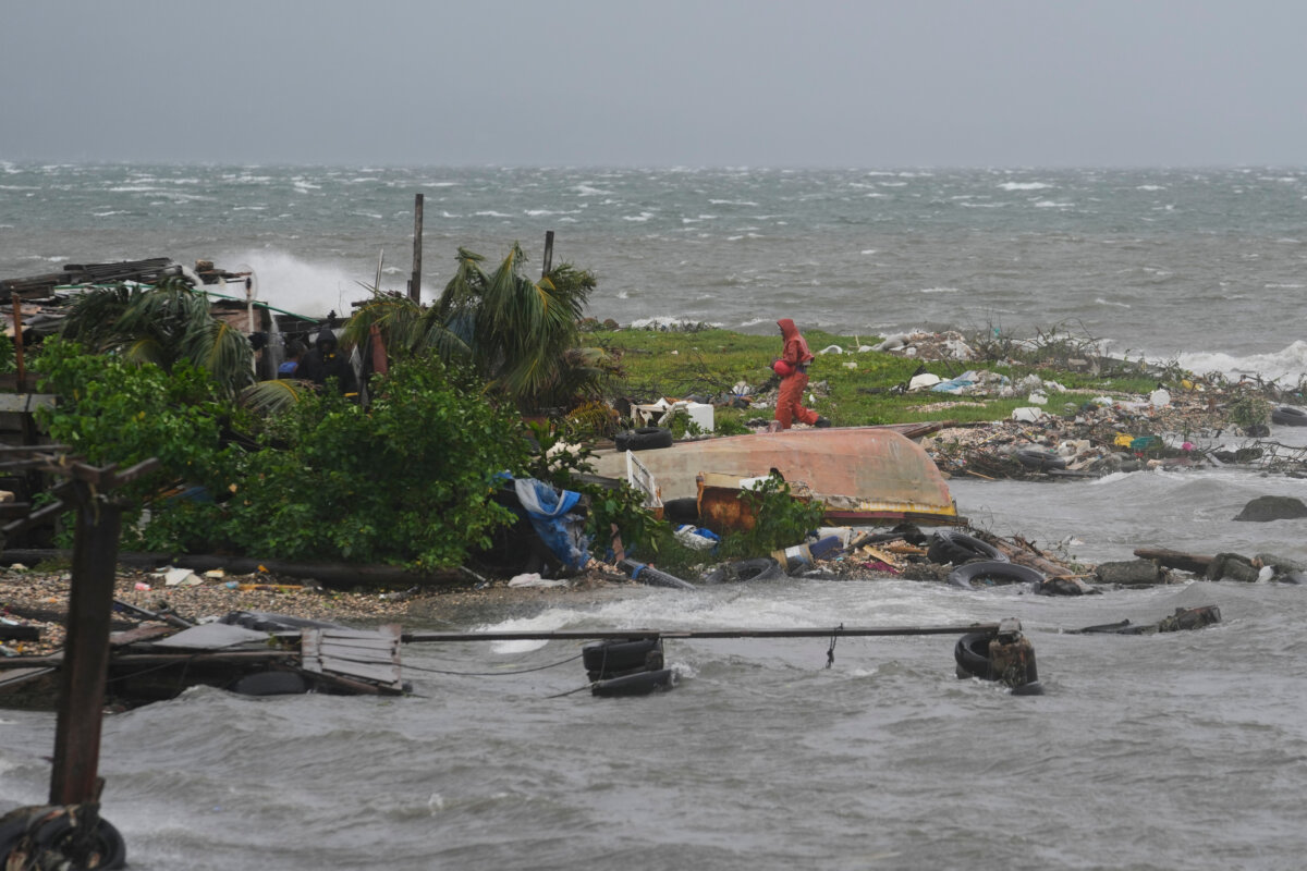 A man walks along the coastline in Kingston, Jamaica. (Matias Delacroix/AP)
