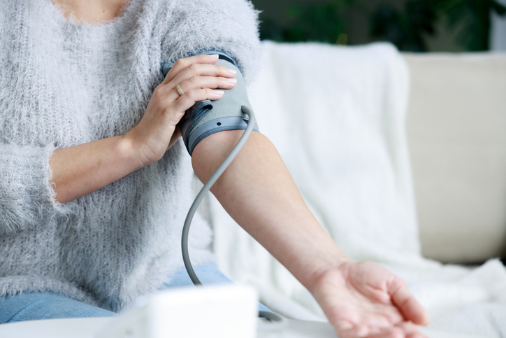 Young woman checking her blood pressure at home. (Source: iStock, eternalcreative)