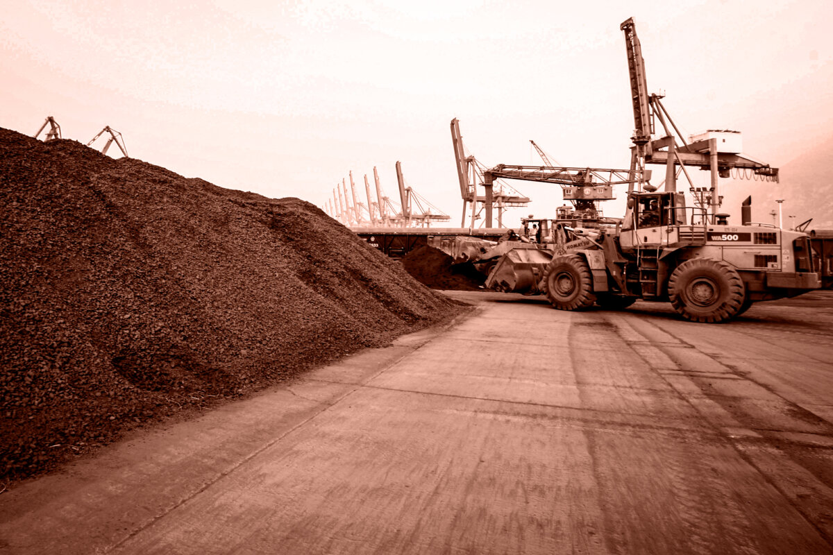 A man drives a frontloader to shift soil containing rare-earth minerals for export to Japan at a port in Lianyungang, Jiangsu Province, China, on Sept. 5, 2010. (Edited by The Epoch Times, STR/AFP via Getty Images)