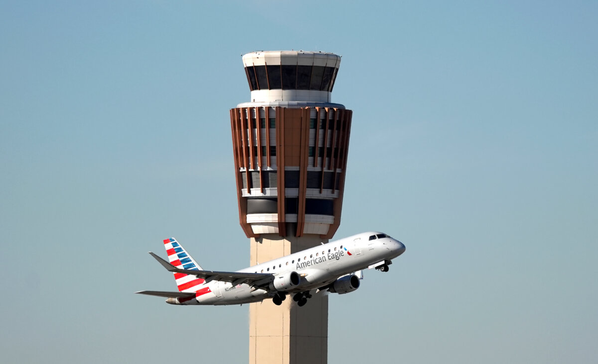 An American Airlines American Eagle jet flies past the air traffic control tower at Phoenix Sky Harbor International Airport, in Phoenix, on Nov. 8, 2025. (AP Photo/Ross D. Franklin)