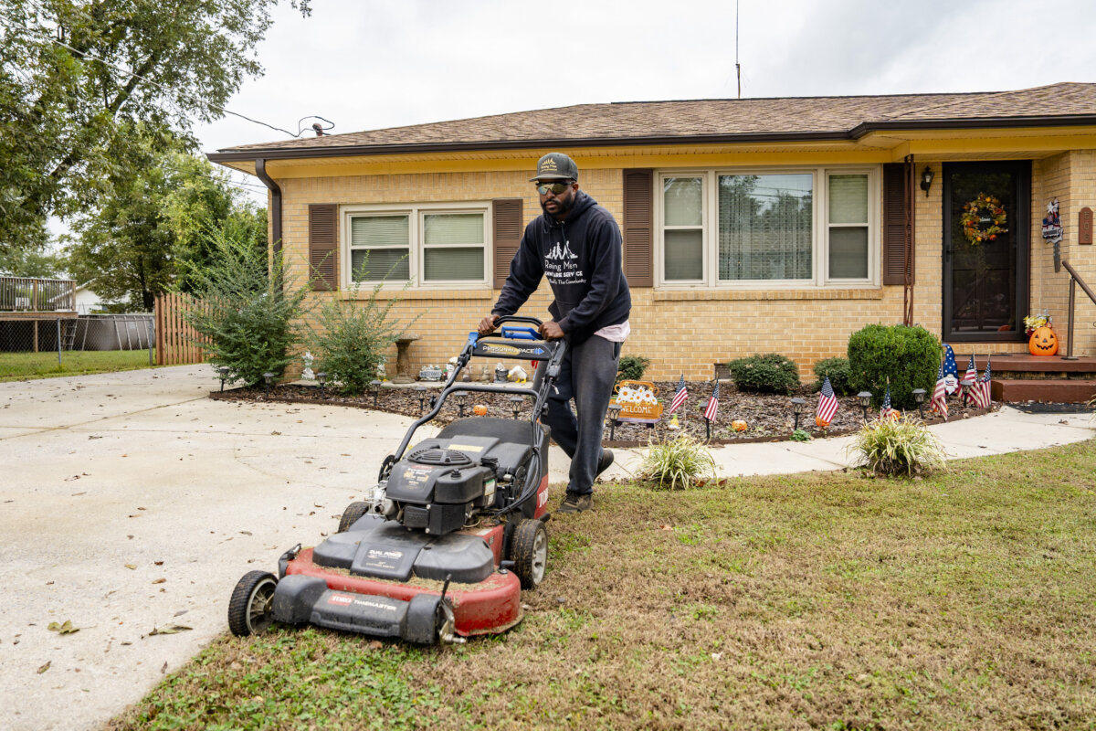 Rodney Smith Jr., founder of Raising Men and Women Lawn Care Service, mows a lawn in Madison, Ala., on Oct. 28, 2025.(Samira Bouaou/The Epoch Times)