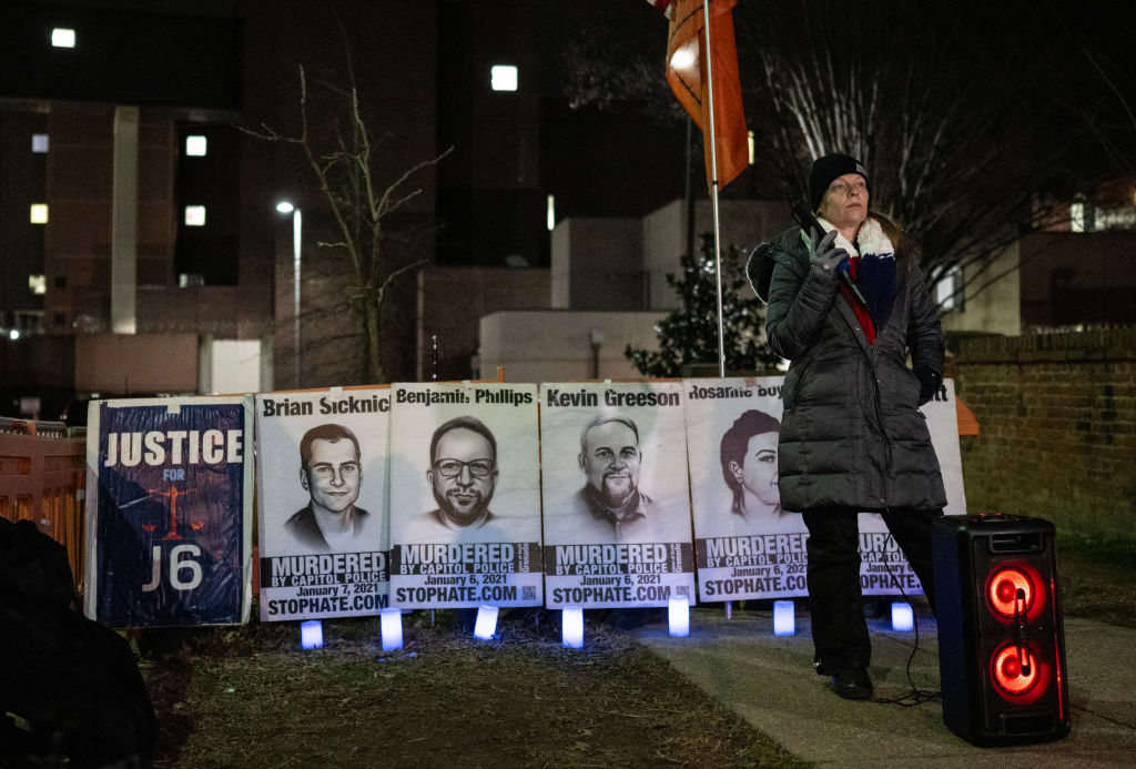 A supporter of Jan. 6 defendants, incarcerated in DC jail, speaks with an inmate during a vigil on Jan. 3, 2024. A dozen people shouted their support for the inmates. (Andrew Caballero-Reynolds/AFP via Getty Images)