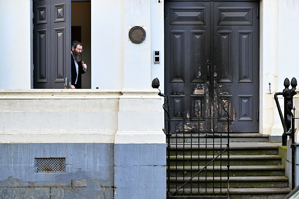 Rabbi Dovid Gutnick speaks to the media next to the burnt front entrance of the East Melbourne Synagogue in Melbourne on July 6, 2025. (William West/AFP/Getty Images)