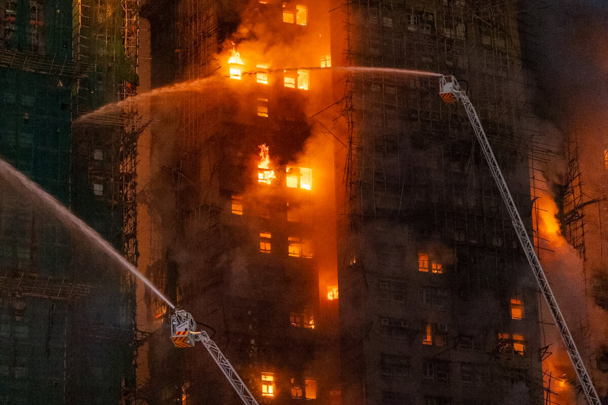 Firefighters try to extinguish flames engulfing a building after a fire broke out at Wang Fuk Court, a residential estate in the Tai Po district of Hong Kong's New Territories, on Nov. 26 2025. (AP Photo/Chan Long Hei)