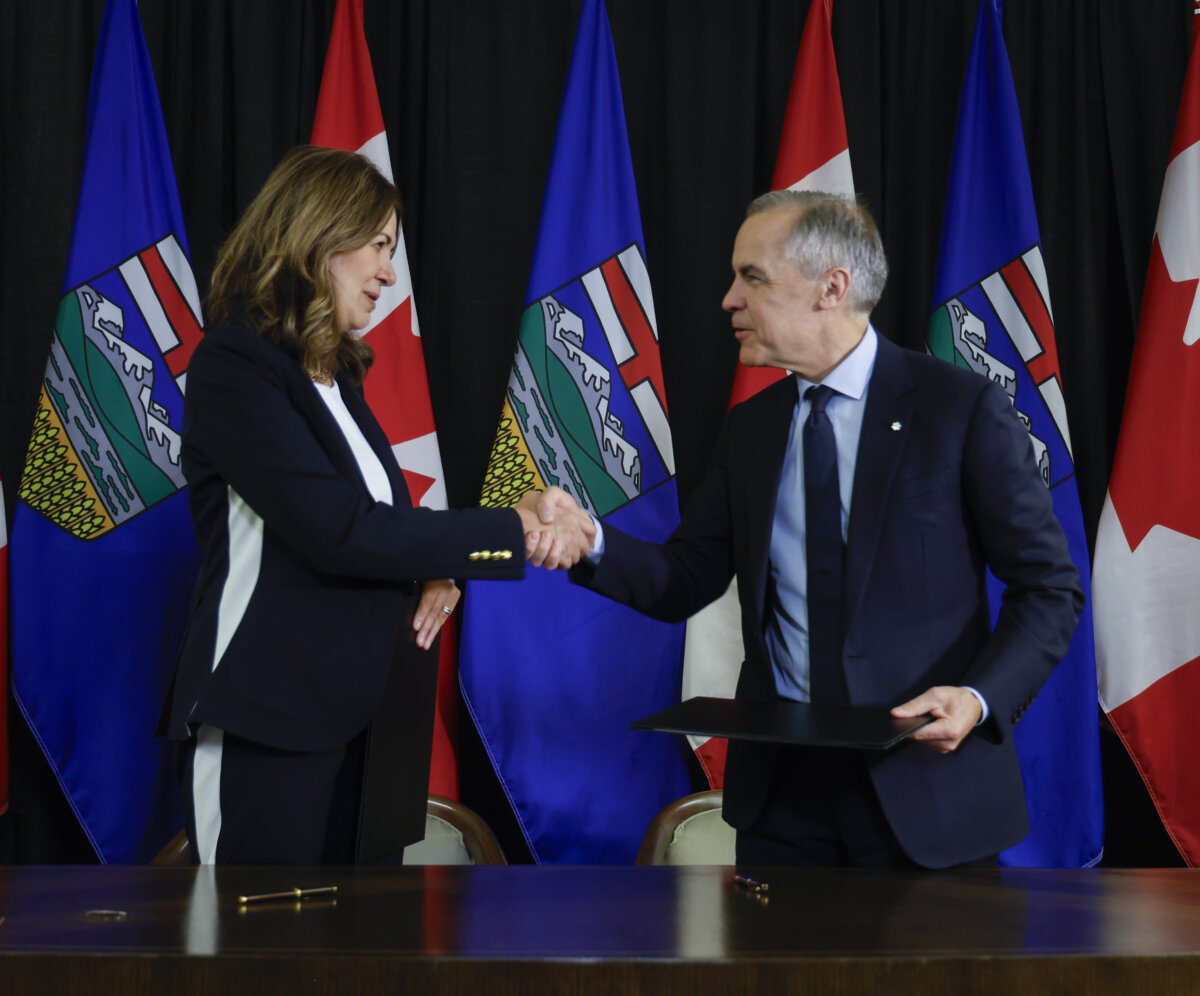 Prime Minister Mark Carney and Alberta Premier Danielle Smith shake hands after signing an MOU in Calgary on Nov. 27, 2025. (The Canadian Press/Jeff McIntosh)