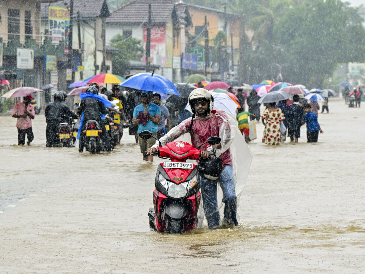 People wade through floodwaters after heavy rainfall in Kaduwela on the outskirts of Colombo, Sri Lanka, on Nov. 28, 2025. Sri Lanka deployed the military for relief and rescue operations on Nov. 28,2025, as the death toll from floods and landslides across the island rose to 56, with another 21 people missing. (Ishara S. Kodikara/AFP via Getty Images)