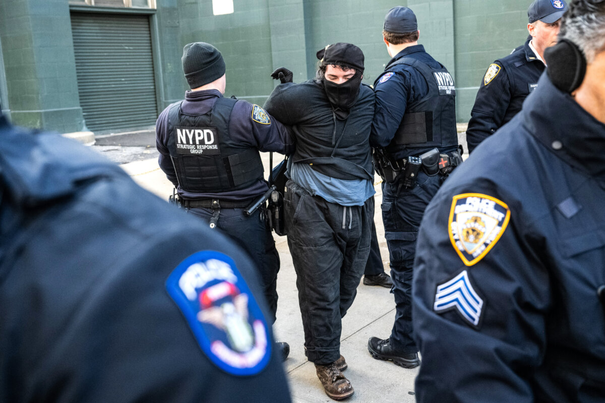 A person is detained by New York Police Department officers as immigration activists block a garage used by Immigration and Customs Enforcement vans during a protest against a purported ICE operation on Canal Street in New York City on Nov. 29, 2025. (Stephanie Keith/Getty Images)