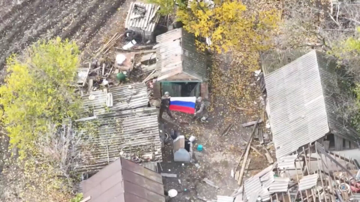 Russian soldiers hold Russia's national flag after, according to the Russian Defence Ministry, its forces took control of the village of Krasnohirske, Zaporizhzhia region, Ukraine, in this still image taken from video released on November 1, 2025. (Russian Defence Ministry/Handout via Reuters)