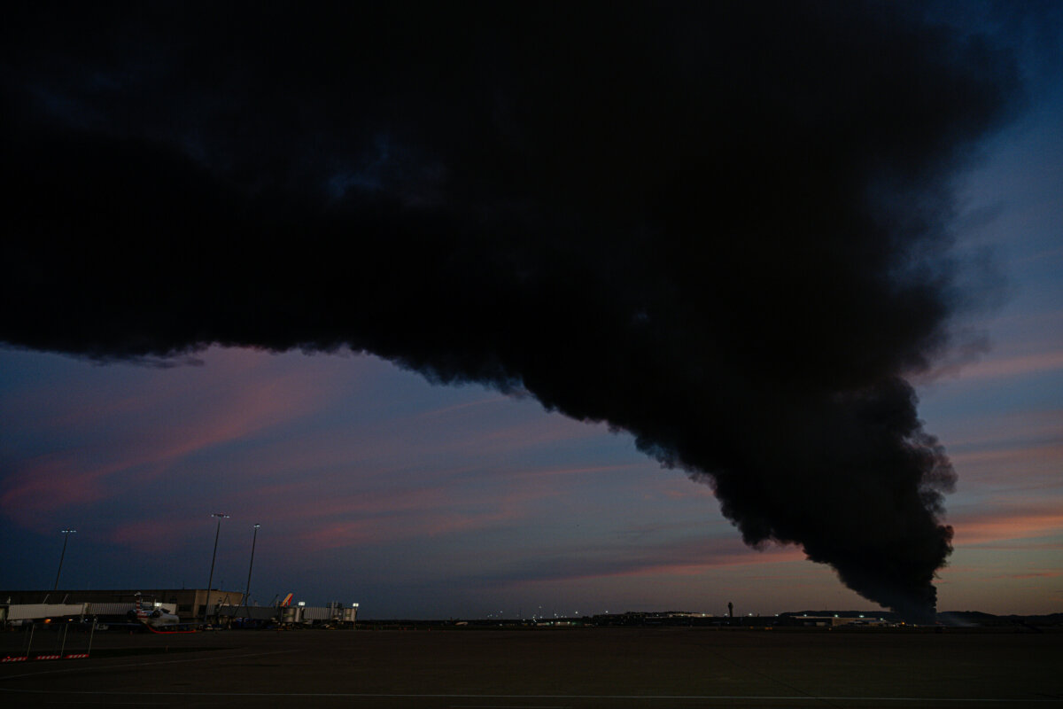 A plume of smoke wafts over airport property after reports of a plane crash at Louisville International Airport in Louisville, Ky., on Nov. 4, 2025. (Jon Cherry/AP Photo)