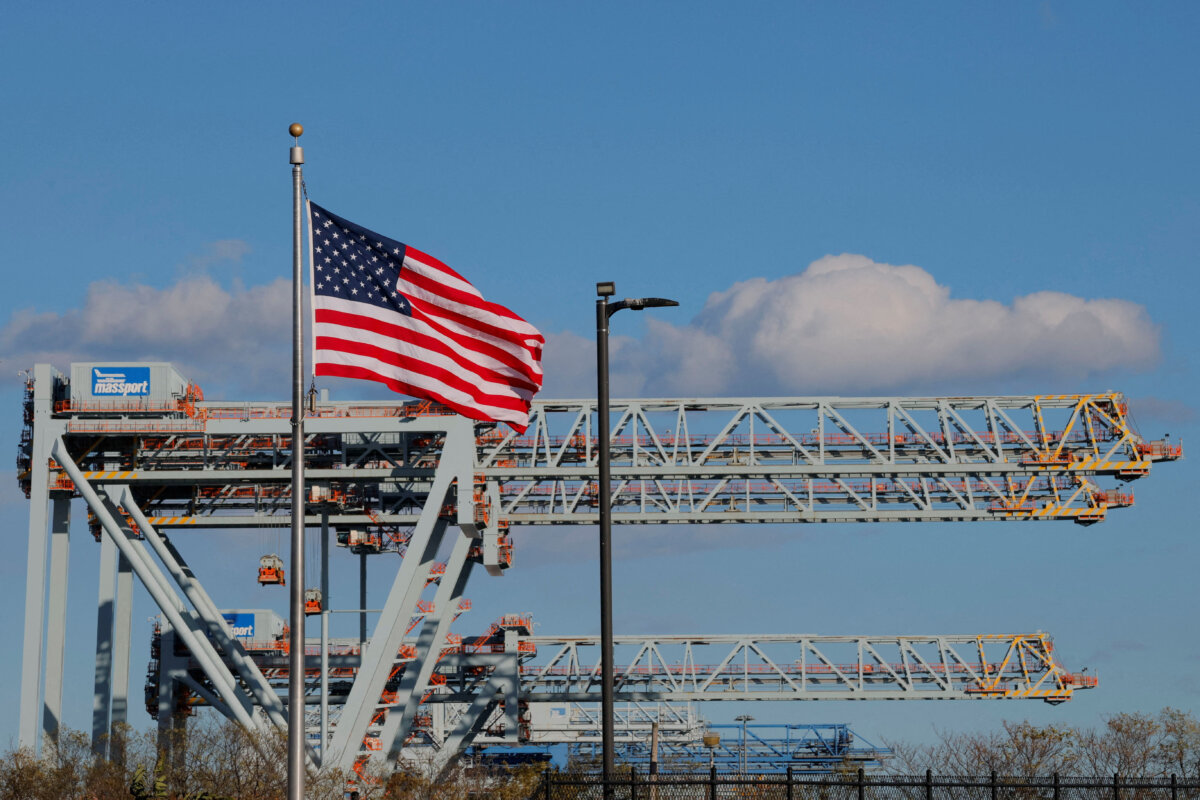 A U.S. flag flies in front of cranes at the Conley Container Terminal in Boston, Mass., on Nov. 4, 2025. (Brian Snyder/Reuters)