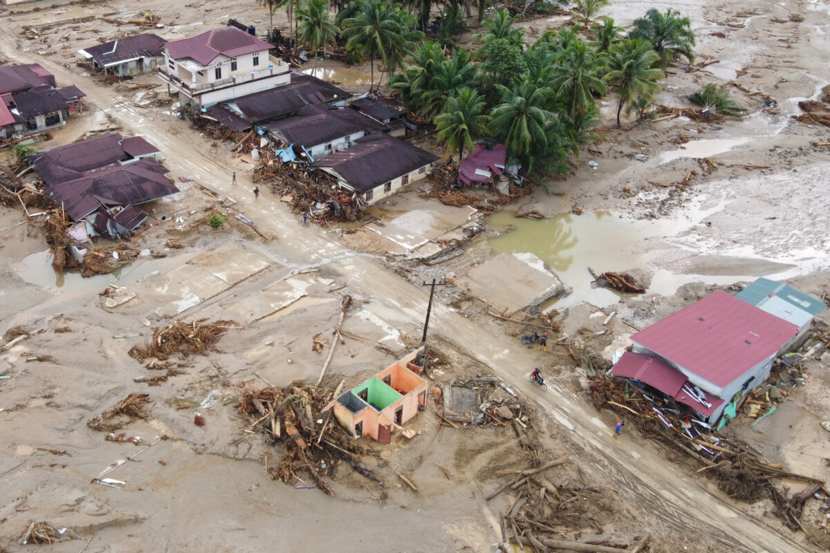 People make their way on a muddy road at a village affected by a flash flood in Batang Toru, North Sumatra, Indonesia, on Dec. 2, 2025. (Binsar Bakkara/AP Photo)