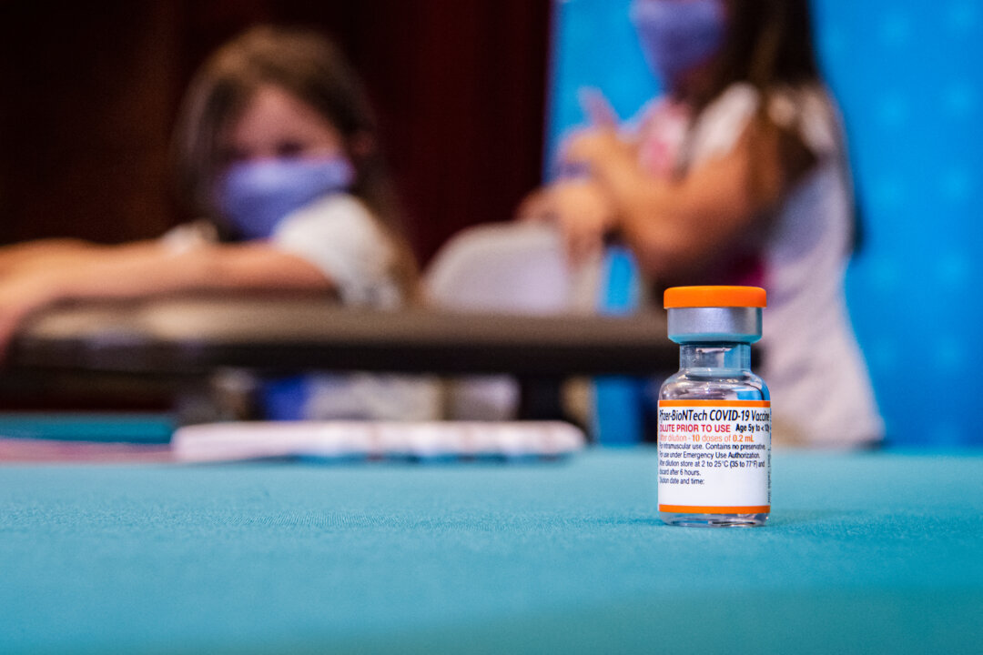 A vial of the children’s dose of the Pfizer-BioNTech COVID-19 vaccine sits in the foreground as children wait to be vaccinated at Hartford Hospital in Hartford, Conn., on Nov. 2, 2021. (Joseph Prezioso/AFP via Getty Images)