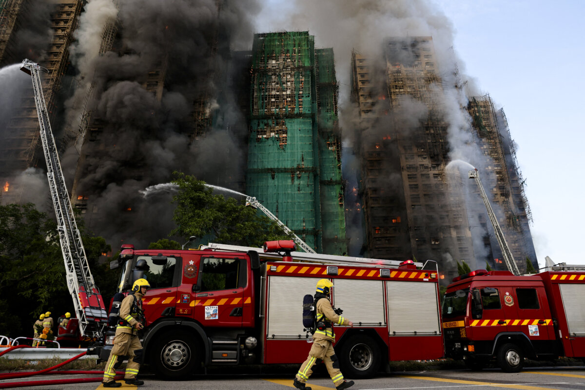 Firefighters work as efforts are underway to extinguish flames engulfing bamboo scaffolding across multiple buildings at the Wang Fuk Court housing estate in Tai Po, Hong Kong, on Nov. 26, 2025. (Tyrone Siu/Reuters)