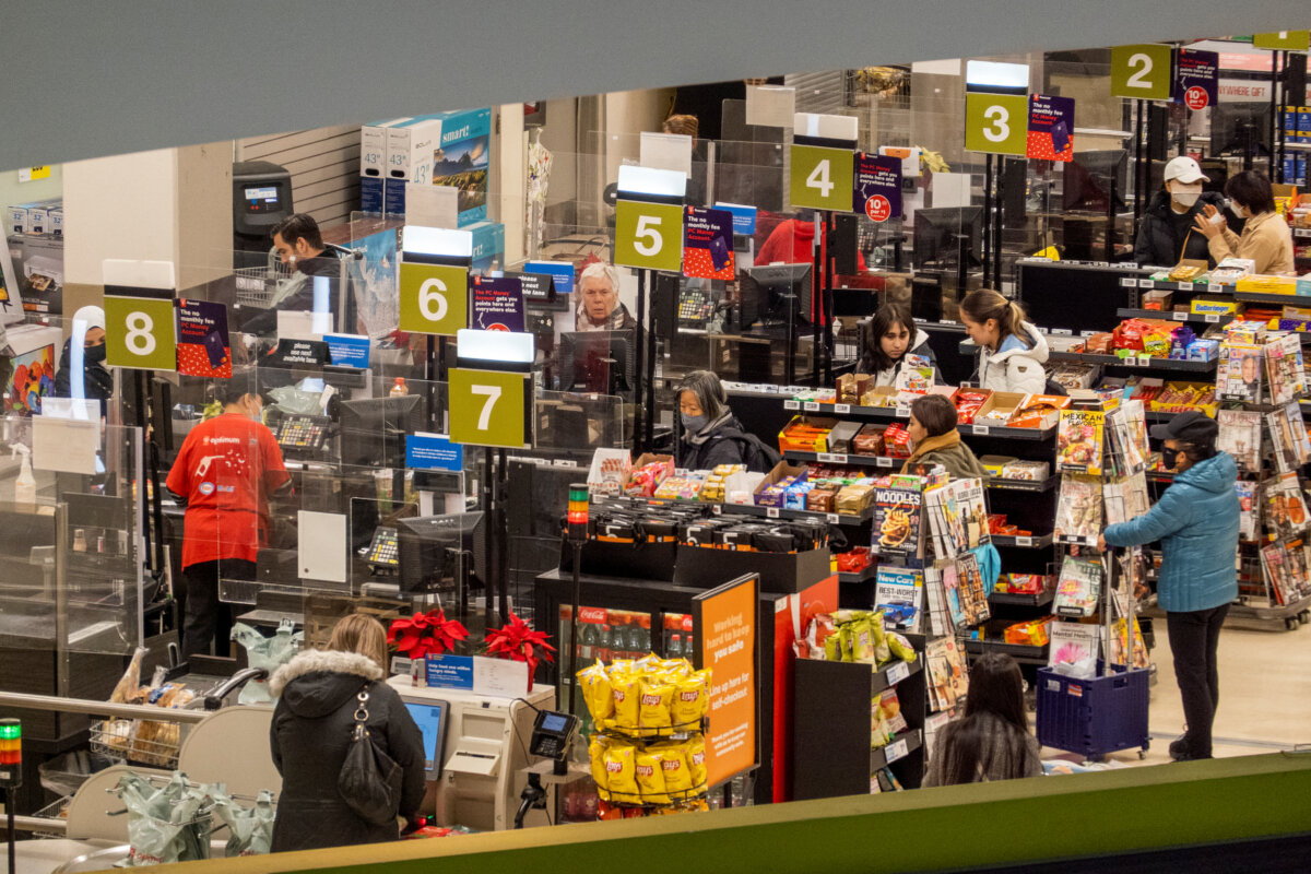 People pay for their items at a grocery store in Toronto, Ont., on Nov. 22, 2022. (Carlos Osorio/Reuters)