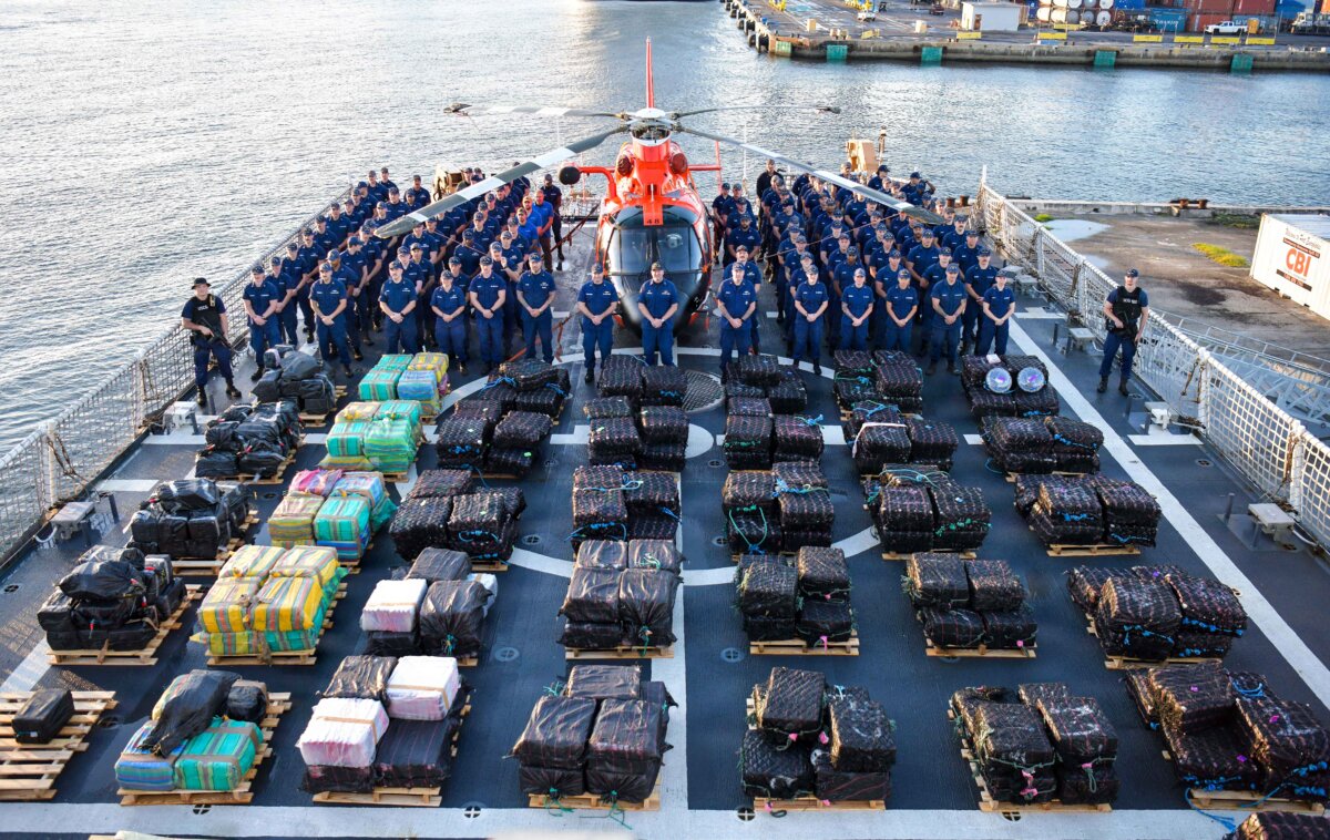 The crew of USCGC James (WMSL 754) poses for a group photo prior to the offload of more than 26,890 pounds of cocaine and marijuana worth more than $198 million at Port Everglades in Fort Lauderdale, Fla., on Dec. 8, 2025. (U.S. Coast Guard photo by Petty Officer 1st Class Diana Sherbs/Public Domain)