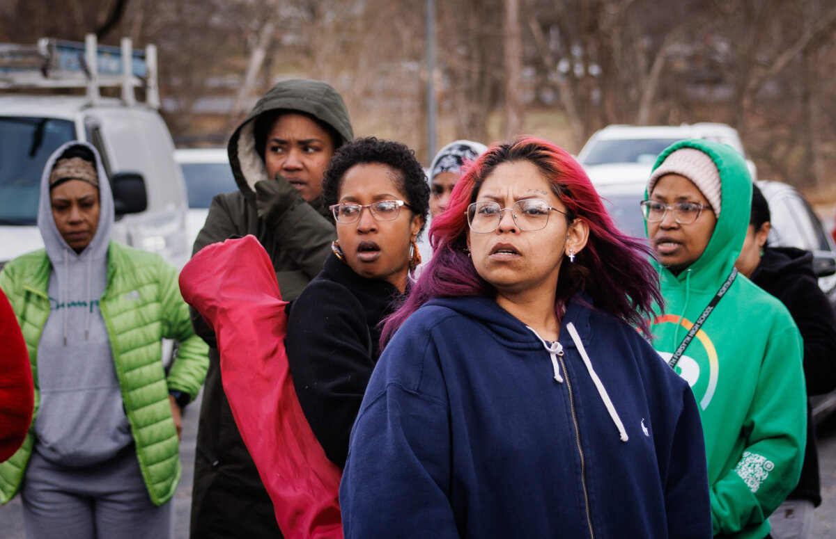 Family members and friends of North Forsyth High School students watch and wait in a parking lot across the street from the school after a fatal stabbing, on Dec. 9, 2025, in Winston-Salem, N.C. (Allison Lee Isley/The Winston-Salem Journal via AP)
