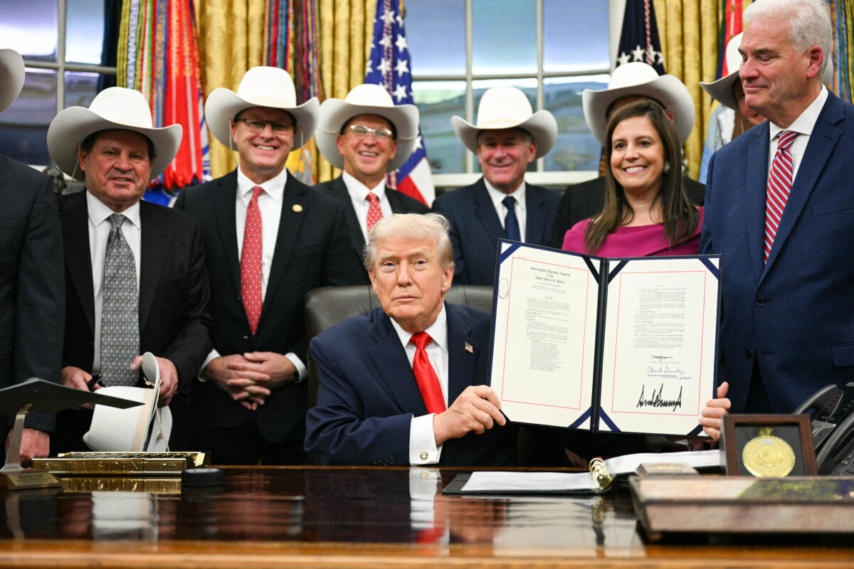 President Donald Trump displays a bill during a ceremony with members of the 1980 U.S. Olympic men's ice hockey team in the Oval Office on Dec. 12, 2025. (Jim Watson/AFP via Getty Images)
