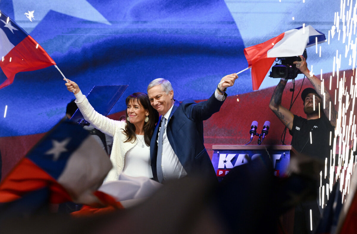 Chile's presidential candidate Jose Antonio Kast (R) of the Partido Republicano party and his wife Maria Pia Adriasola (L) wave national flags as they celebrate the results of the presidential runoff election in Santiago, Chile, on Dec. 14, 2025. (Eitan Abramovich/AFP via Getty Images)