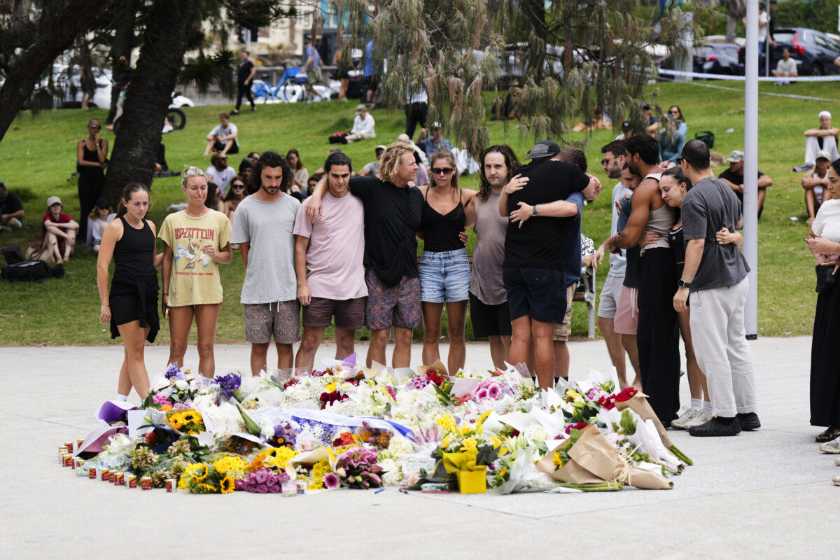 People embrace after laying flowers at a memorial outside Bondi Pavilion at Sydney's Bondi Beach on Dec. 15, 2025, a day after a mass shooting that left 15 people dead. (Mark Baker/AP Photo)