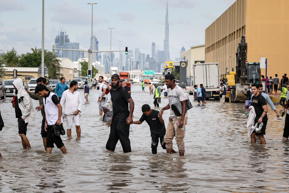 People wade through floodwaters after heavy rains in Dubai, United Arab Emirates, on Dec. 19, 2025.
(Fadel Senna/AFP via Getty Images)