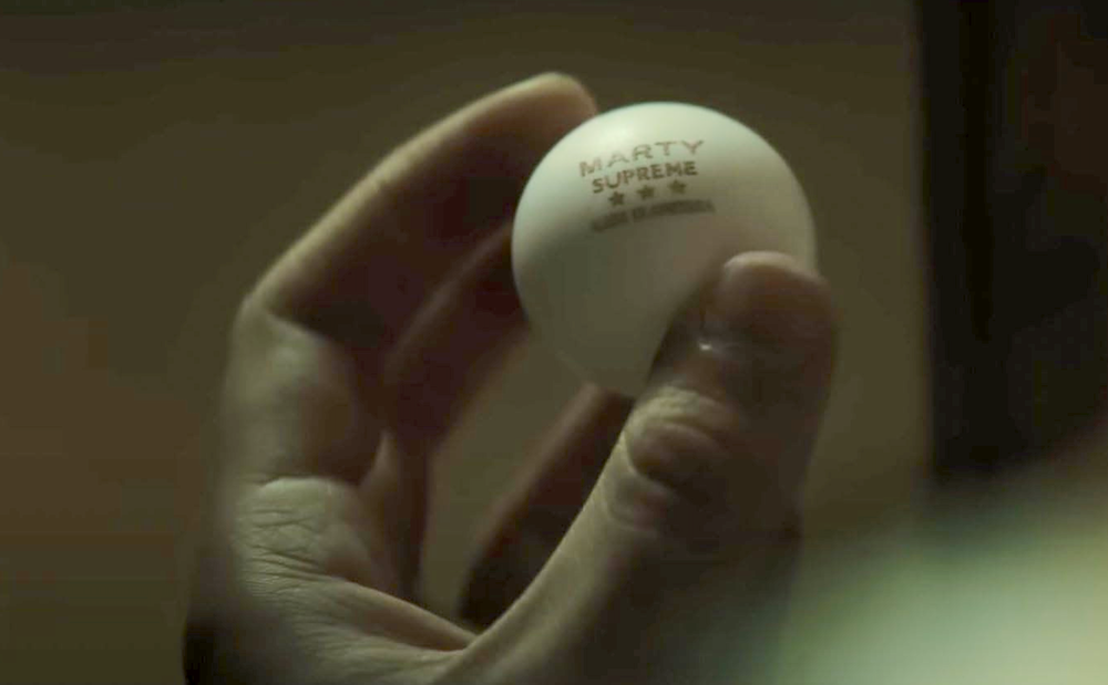 hand holding ping pong ball in Marty Supreme